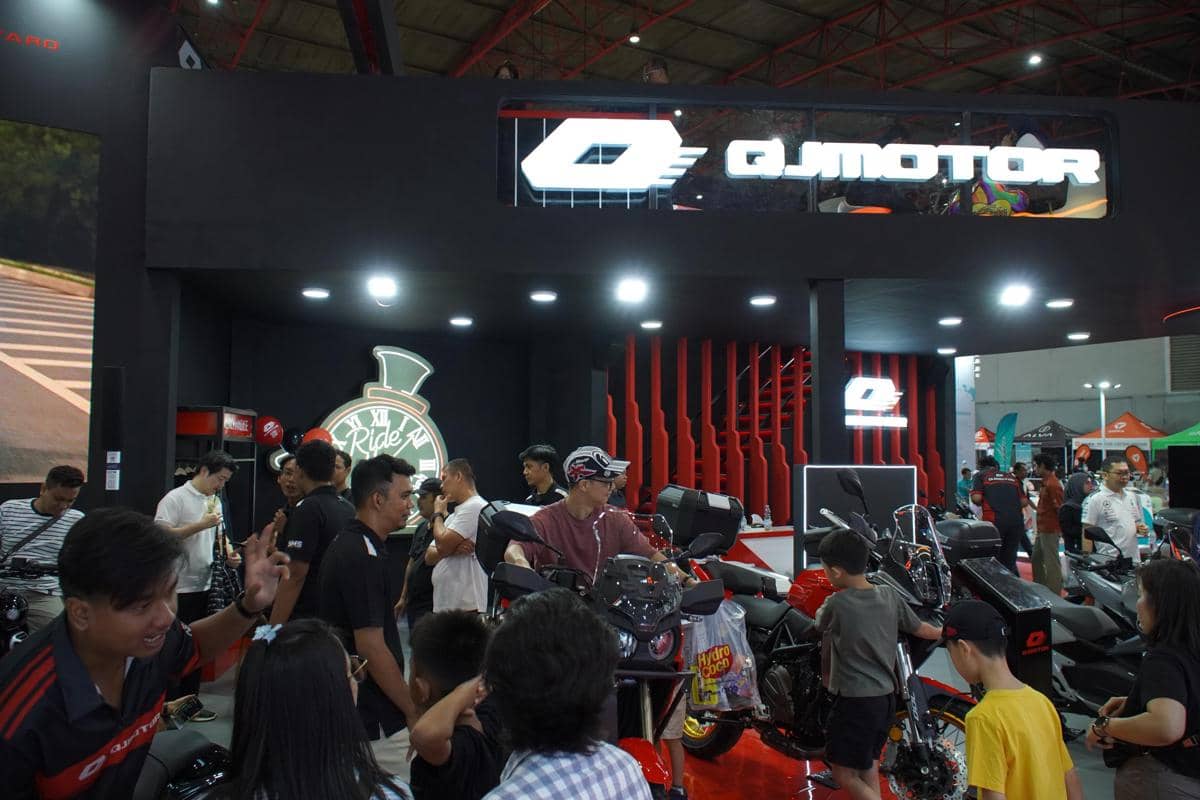 Pengunjung melihat deretan motor di booth QJMotor pada ajang JFK 2026 dengan pencahayaan terang dan desain stan modern.