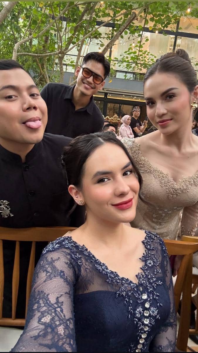 Empat tamu berpakaian formal berfoto selfie di acara akad Jennifer Coppen dan Justin Hubner dengan latar suasana outdoor yang elegan.