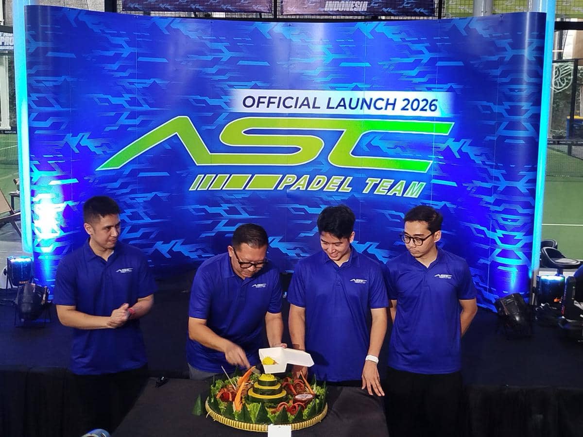 Empat pria mengenakan kaus biru saat peluncuran resmi ASC Padel Team 2026, salah satunya memotong tumpeng di atas meja.