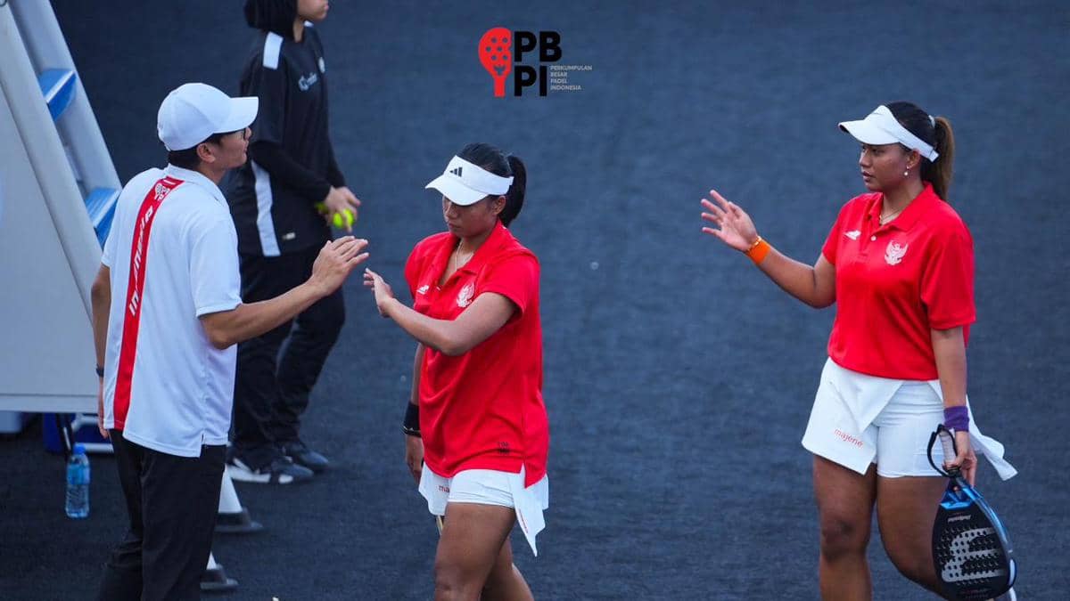 Pelatih dan dua atlet padel Indonesia mengenakan seragam merah dan putih berinteraksi di lapangan dalam kegiatan PBPI.