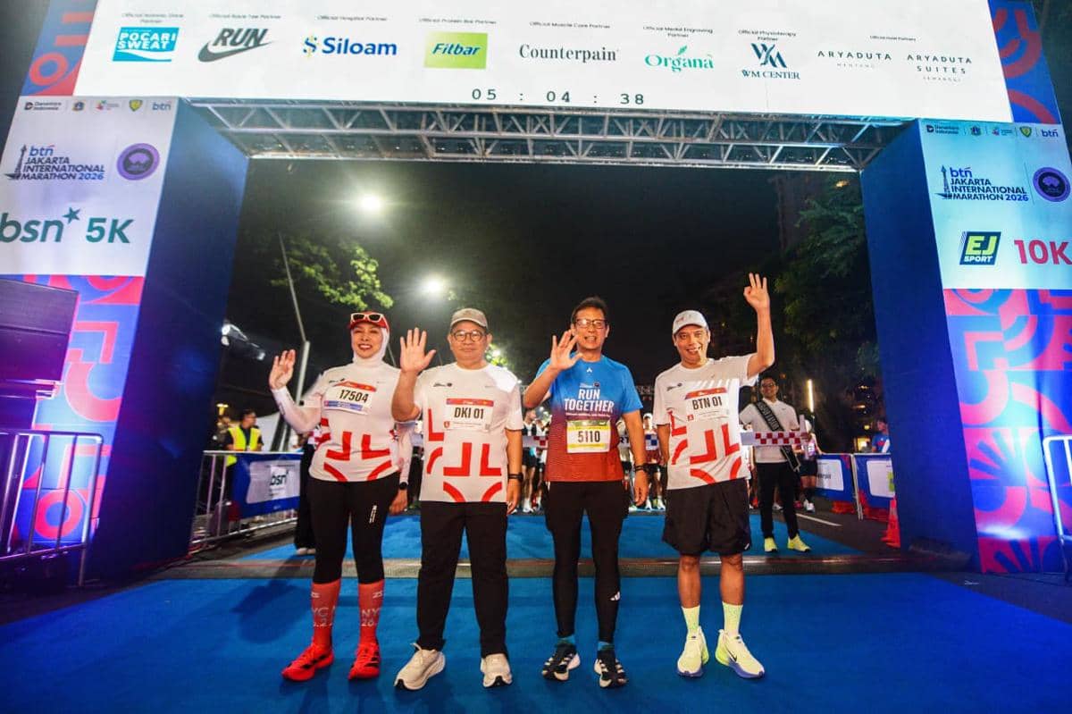 Empat pelari berpose di garis start BTN Jakarta International Marathon 2026, mengenakan pakaian olahraga dengan nomor peserta.