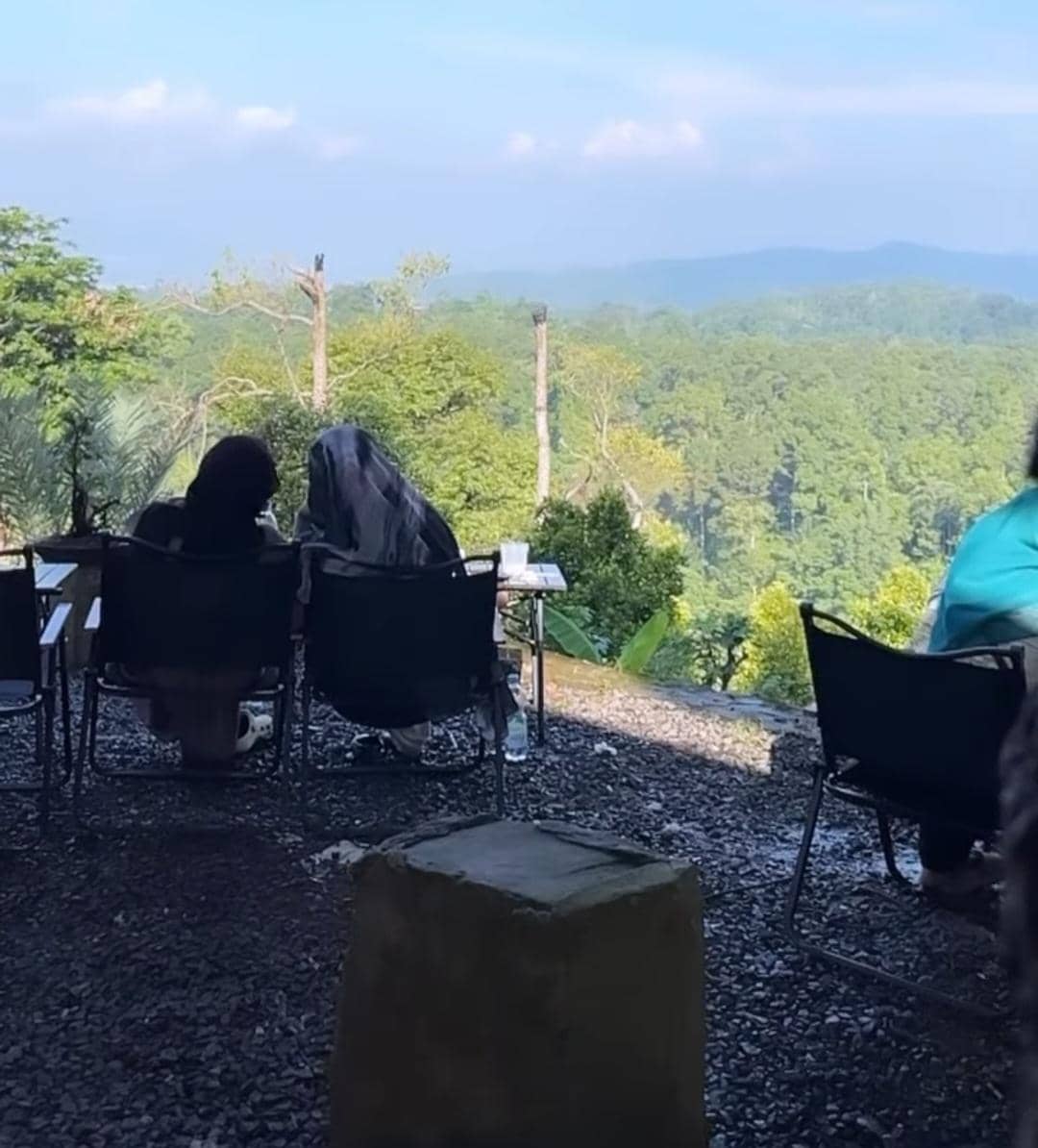 Beberapa pengunjung duduk di area outdoor Ramen Meledak Kaizen Kemiling Bandar Lampung dengan pemandangan hutan hijau dan perbukitan.
