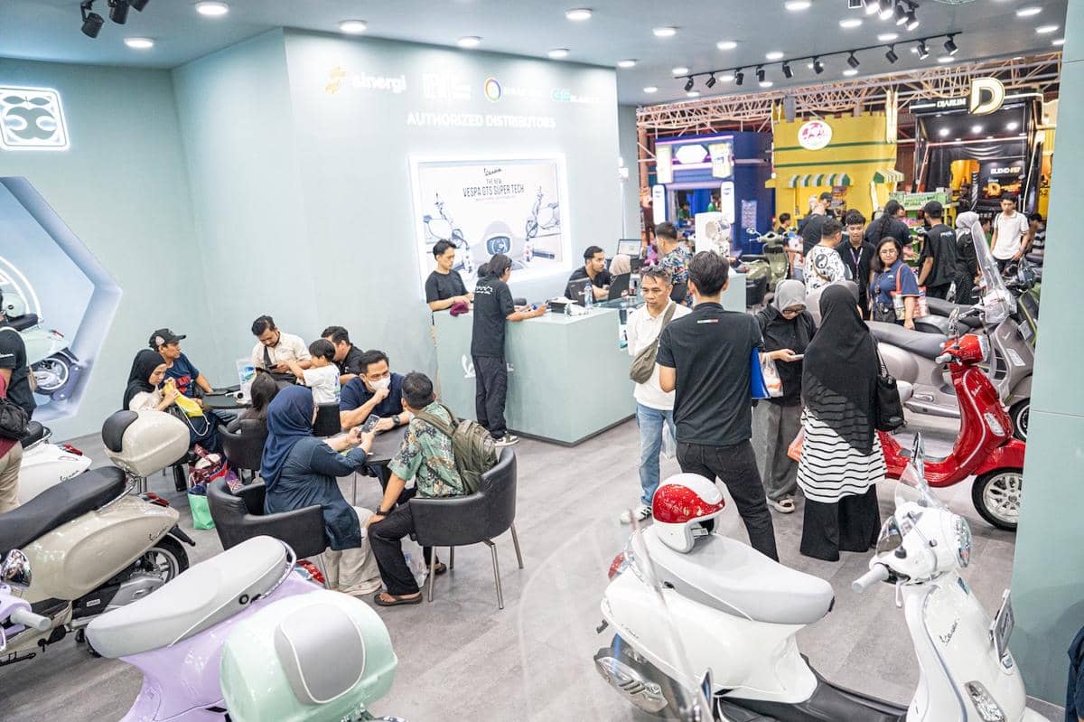 Pengunjung memadati stan Piaggio yang memamerkan berbagai model skuter Vespa di ajang JFK 2026 dengan suasana ramai dan interaktif.