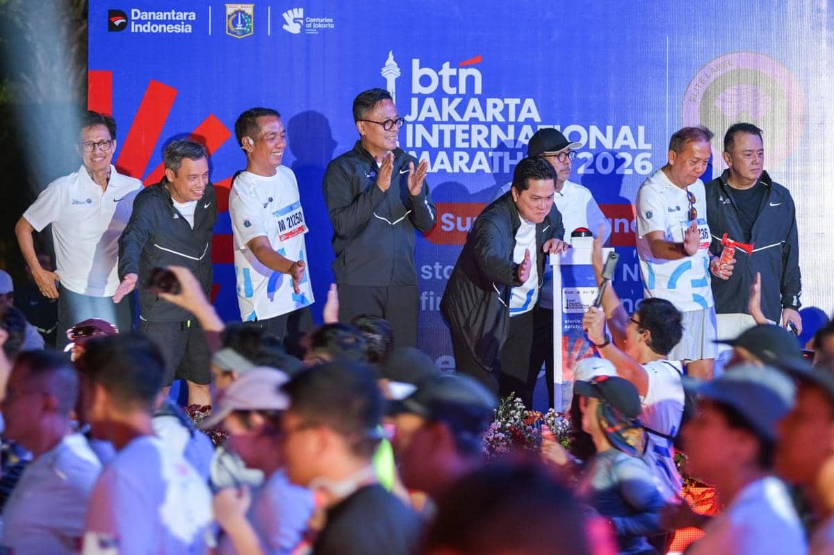 Sejumlah pejabat dan peserta bersemangat di acara BTN Jakarta International Marathon 2026 dengan latar belakang panggung resmi.