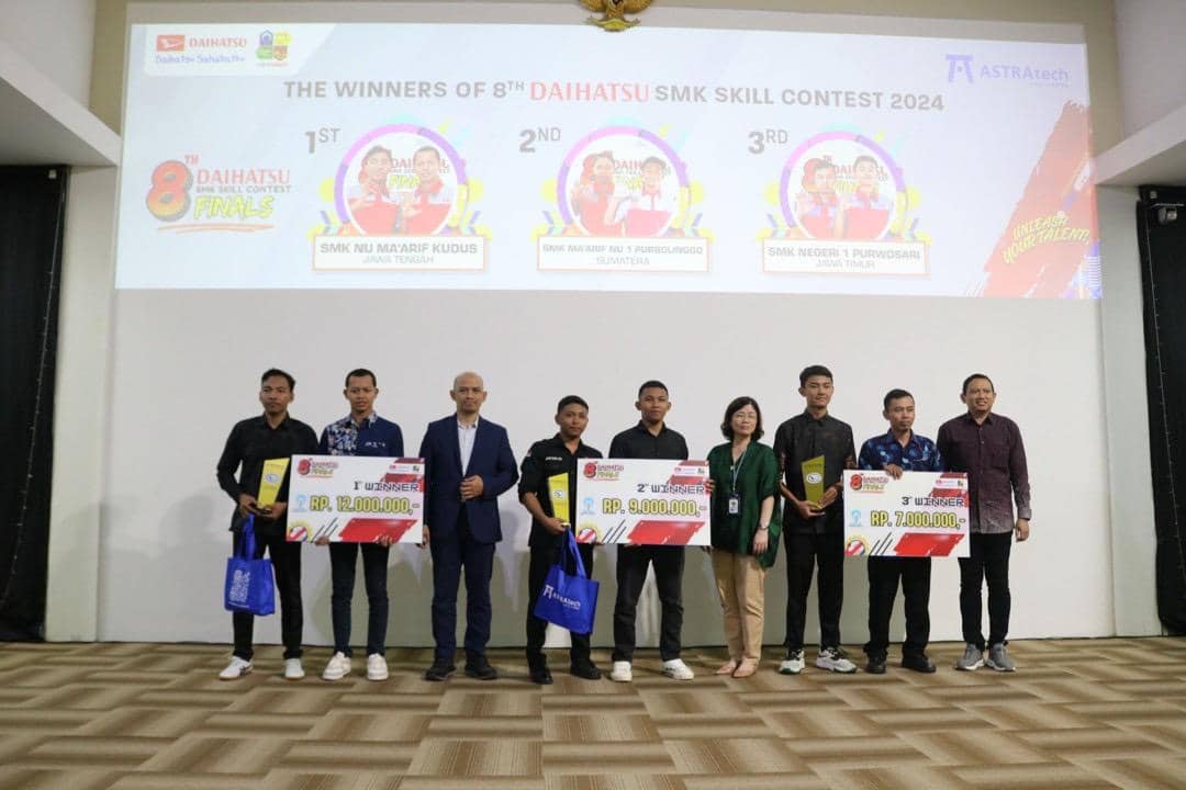 Para pemenang Daihatsu SMK Skill Contest 2024 berpose di atas panggung bersama panitia dan perwakilan penyelenggara sambil memegang hadiah.
