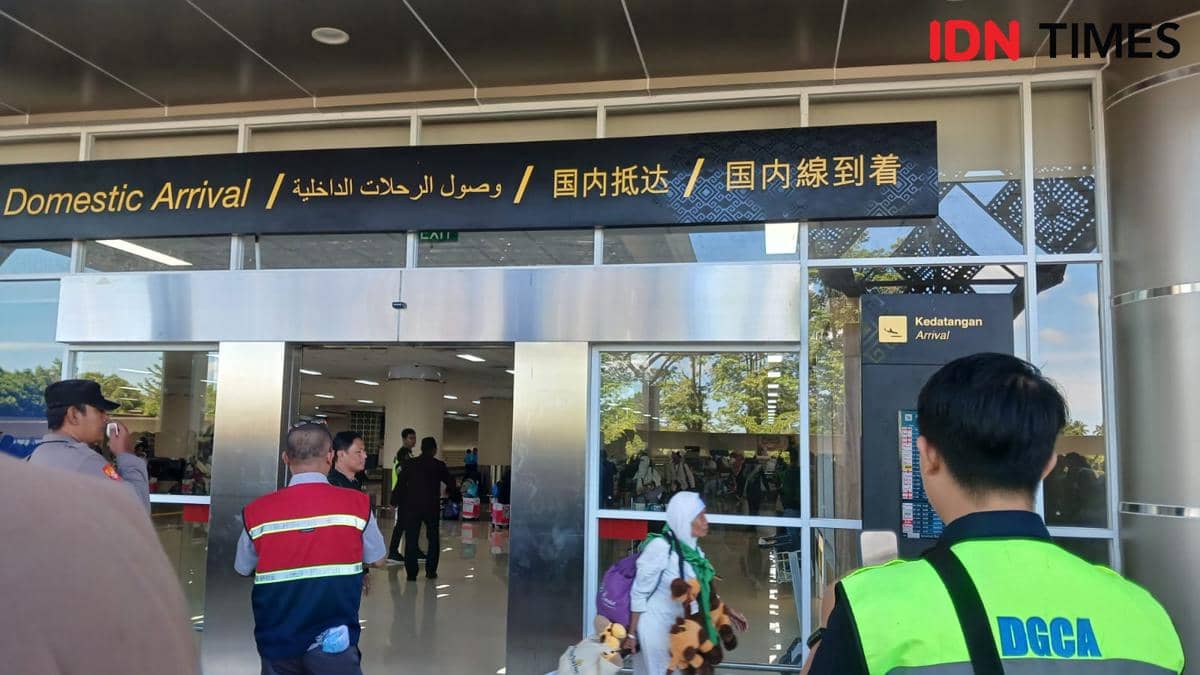 Jemaah haji asal Sulawesi Utara tiba di area kedatangan domestik Bandara Sam Ratulangi Manado dengan petugas bandara menyambut.