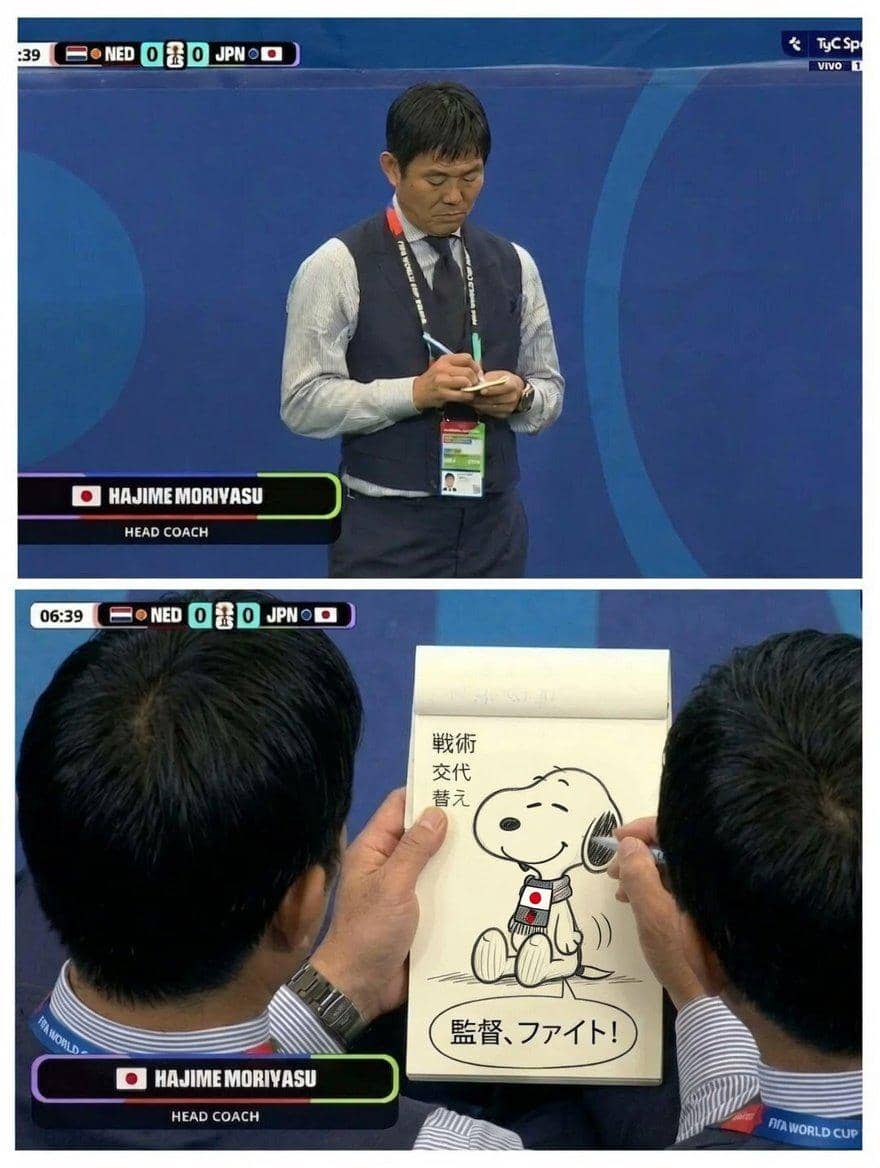 Pelatih tim nasional Jepang menulis di buku catatan saat pertandingan melawan Belanda, dengan gambar Snoopy mengenakan syal bendera Jepang di halaman catatan.