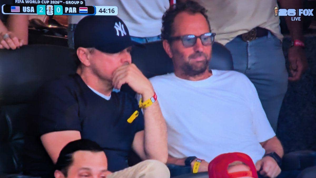 Dua pria duduk di tribun stadion menyaksikan pertandingan Piala Dunia 2026 antara Amerika Serikat dan Paraguay.