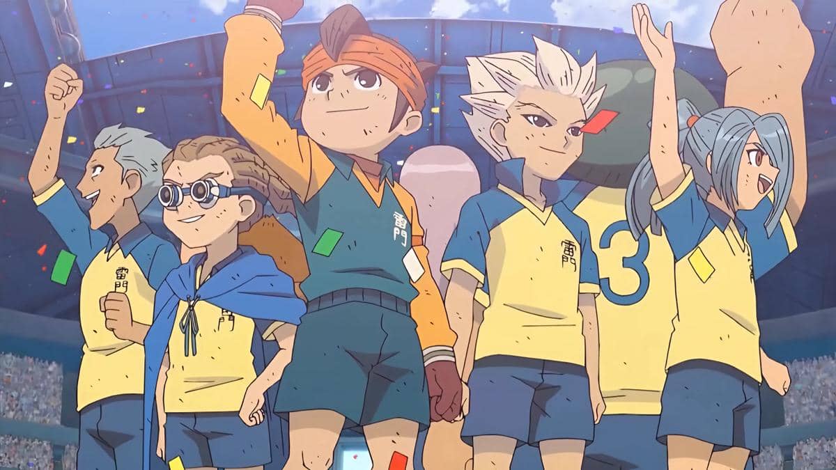 Karakter anime Inazuma Eleven mengenakan seragam sepak bola kuning dan biru sedang merayakan kemenangan di stadion penuh penonton.