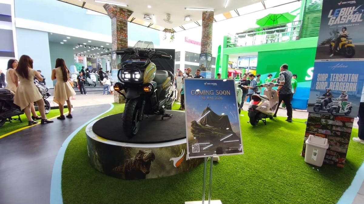 Motor baru dipamerkan di atas panggung kecil dengan papan pengumuman bertuliskan 'Coming Soon 20 Juni 2026' di area pameran kendaraan.