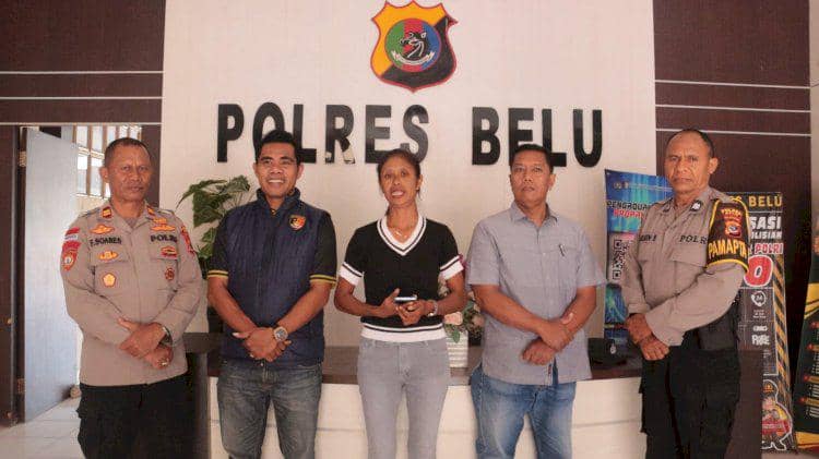 Seorang guru di Belu, Nusa Tenggara Timur, berdiri bersama beberapa anggota kepolisian di kantor Polres Belu setelah kasus pencurian diselesaikan secara damai.