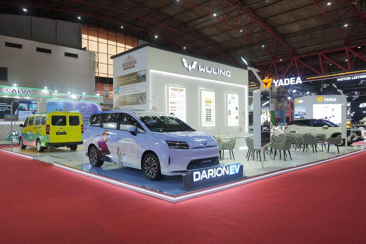 Booth Wuling menampilkan mobil listrik Air EV dan area promosi di pameran otomotif dengan pencahayaan modern dan desain futuristik.