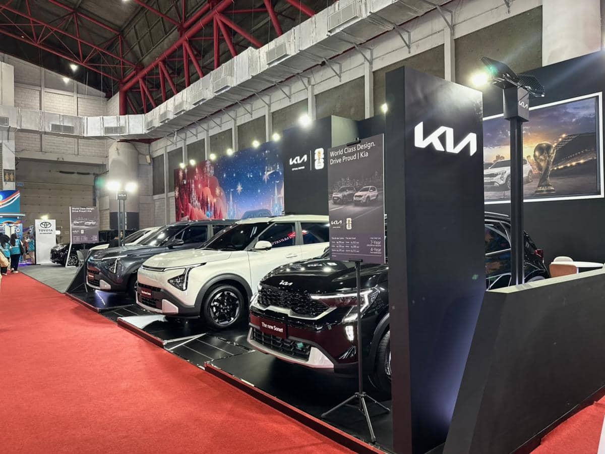 Deretan mobil Kia berbagai model dipamerkan di booth Kia pada ajang JFK 2026 dengan pencahayaan terang dan dekorasi modern.