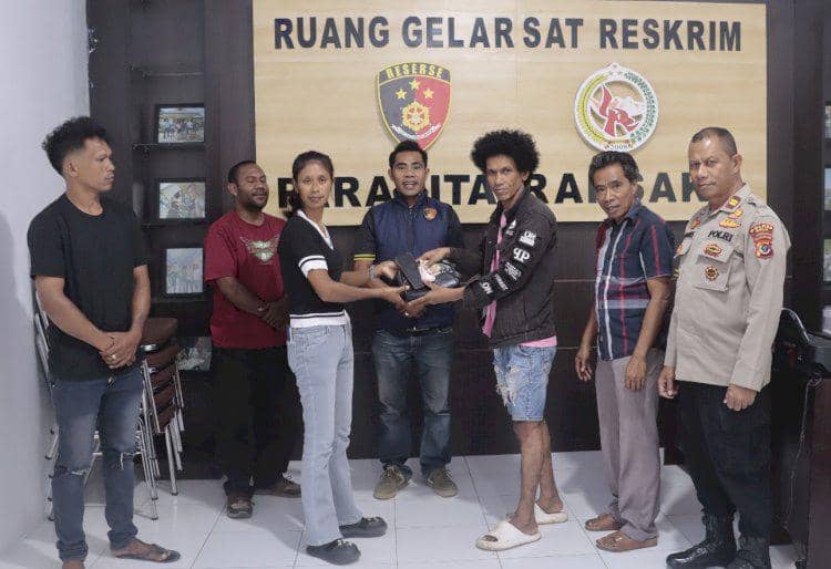 Seorang guru di Belu, NTT, berjabat tangan dengan pria yang mencuri ponsel dan uangnya di ruang Sat Reskrim Polres Belu, disaksikan beberapa orang dan petugas polisi.