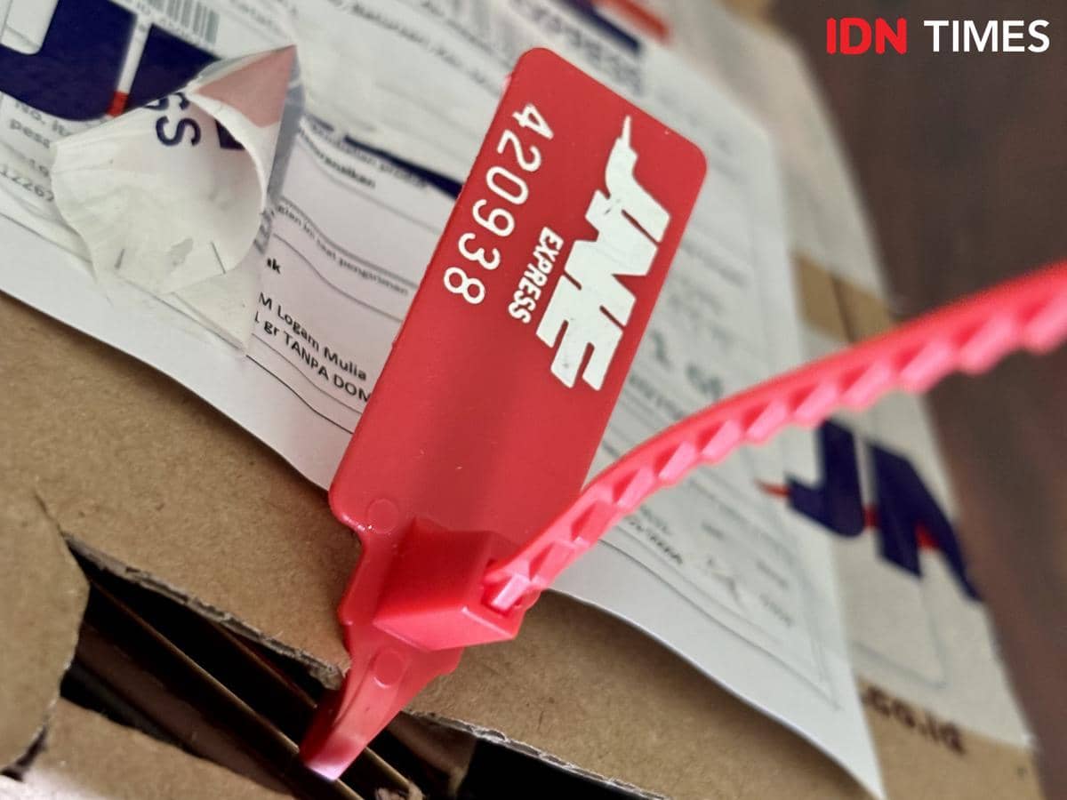 Paket pesanan Fia bersegel merah berisi emas logam mulia yang diantar melalui ekspedisi JNE. (IDN Times/Dhana Kencana)