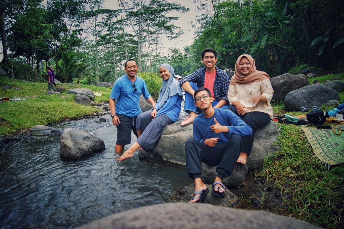 ilustrasi keluarga berfoto di tempat wisata