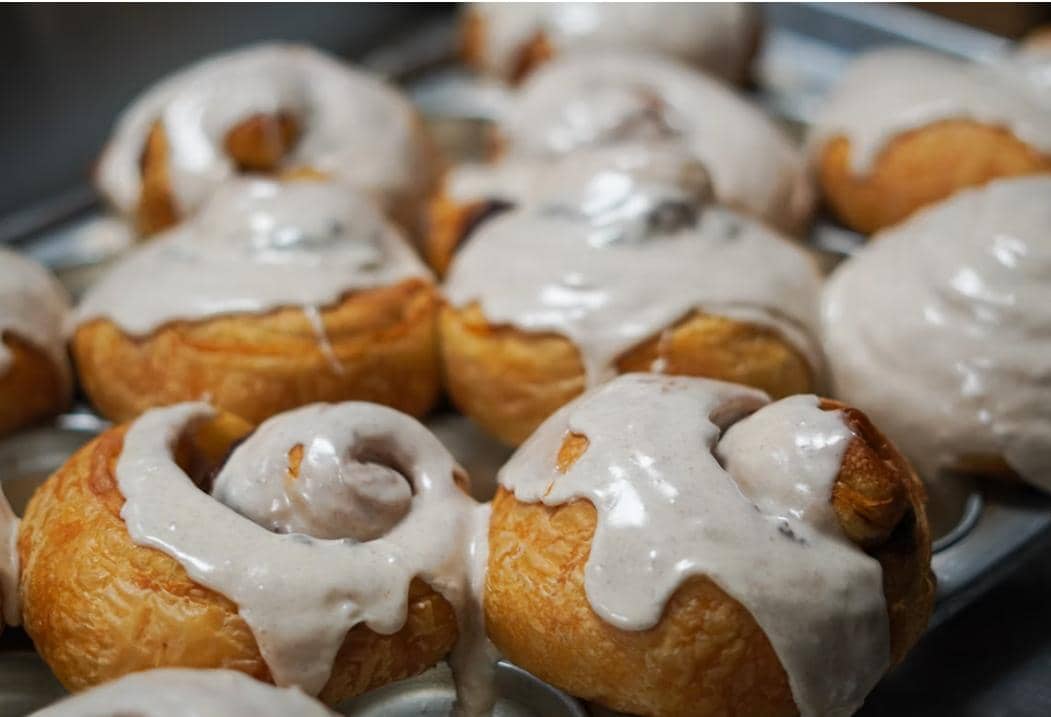 Cinnamon bun bites berwarna cokelat keemasan dengan lapisan gula, disajikan sebagai ilustrasi makanan manis.