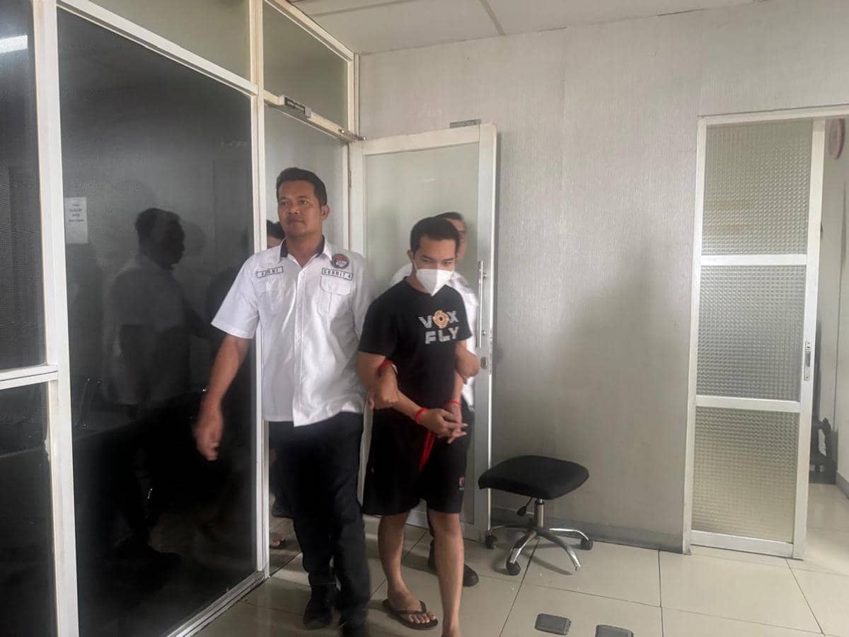 Petugas kepolisian menggiring seorang pria yang diduga pelaku penyelundupan narkoba di Bandara Soekarno-Hatta.