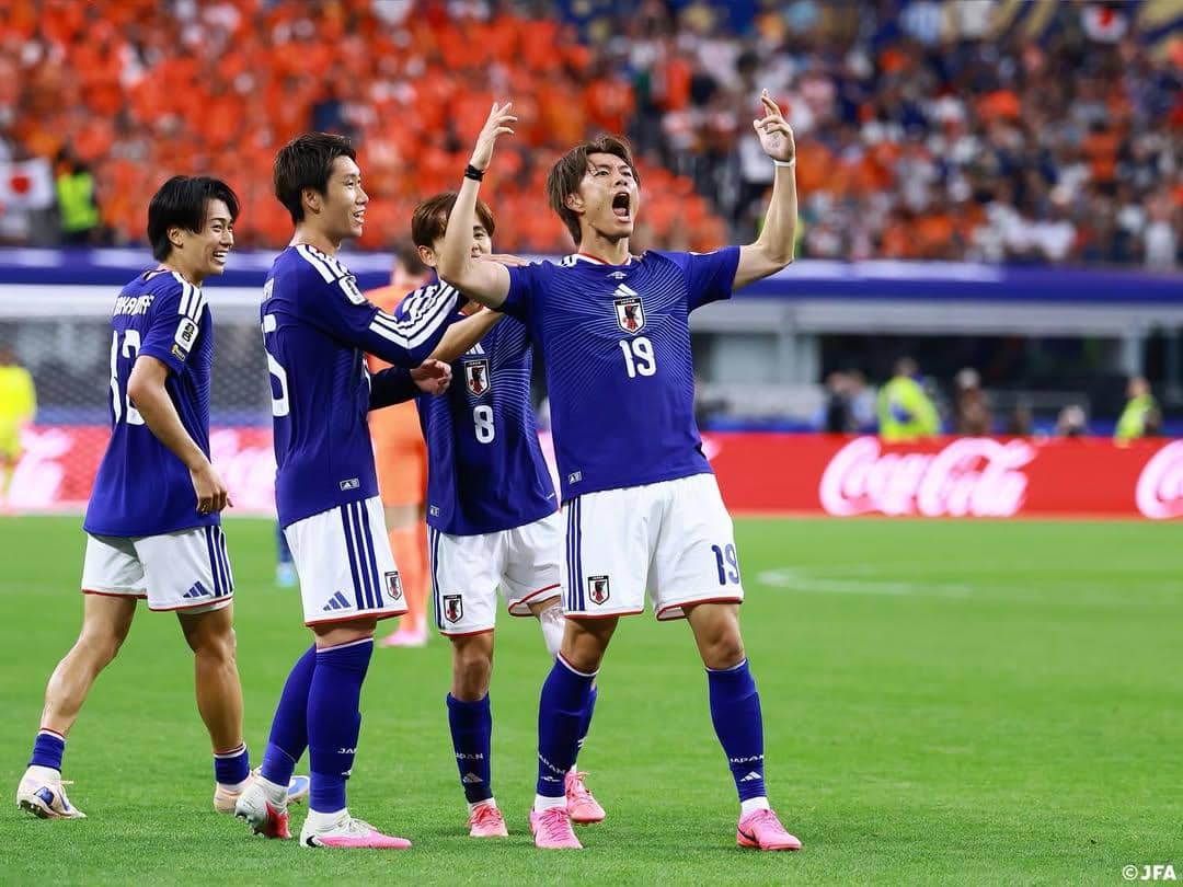 Pemain timnas Jepang mengenakan seragam biru merayakan gol di lapangan saat pertandingan Piala Dunia 2026 dengan latar penonton di stadion.