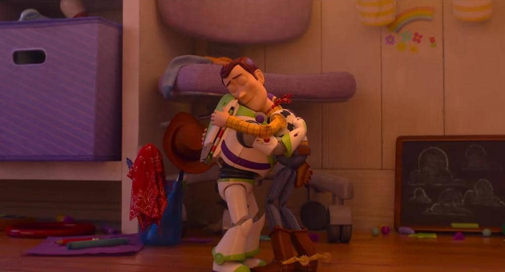 Dua karakter animasi dari film Toy Story 5 berpelukan hangat di dalam kamar anak dengan suasana penuh warna dan mainan di sekitarnya.