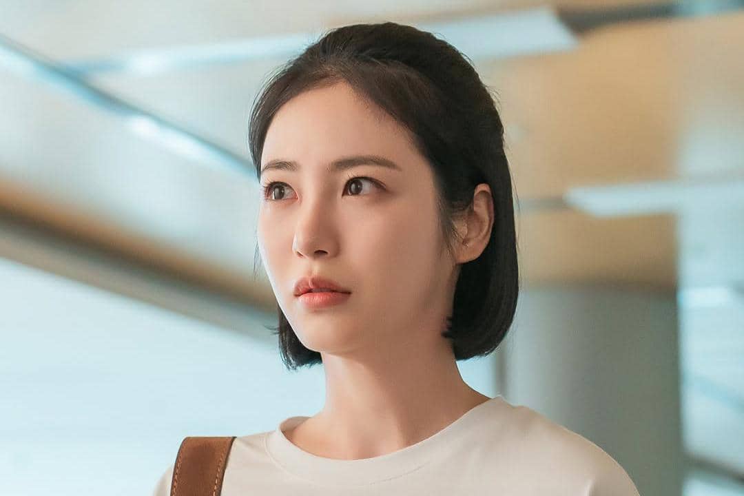 Seorang wanita berambut pendek mengenakan kaus putih tampak serius di sebuah adegan drama Doctor on the Edge.