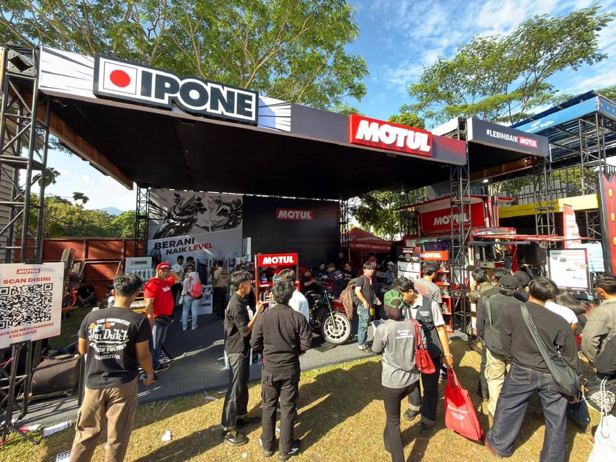 Stan Motul dan Ipone di acara BBQ Ride 2026 dipadati pengunjung yang melihat produk pelumas motor di area luar ruangan.