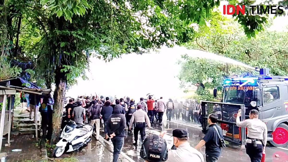 Petugas kepolisian menggunakan mobil water cannon untuk membubarkan massa demonstran di depan Kantor DPRD Sulawesi Utara, Manado.