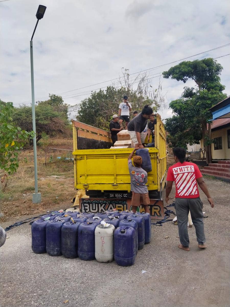 Petugas menurunkan jeriken berisi minyak tanah dari truk kuning saat pengungkapan kasus penyelundupan di Nusa Tenggara Timur.