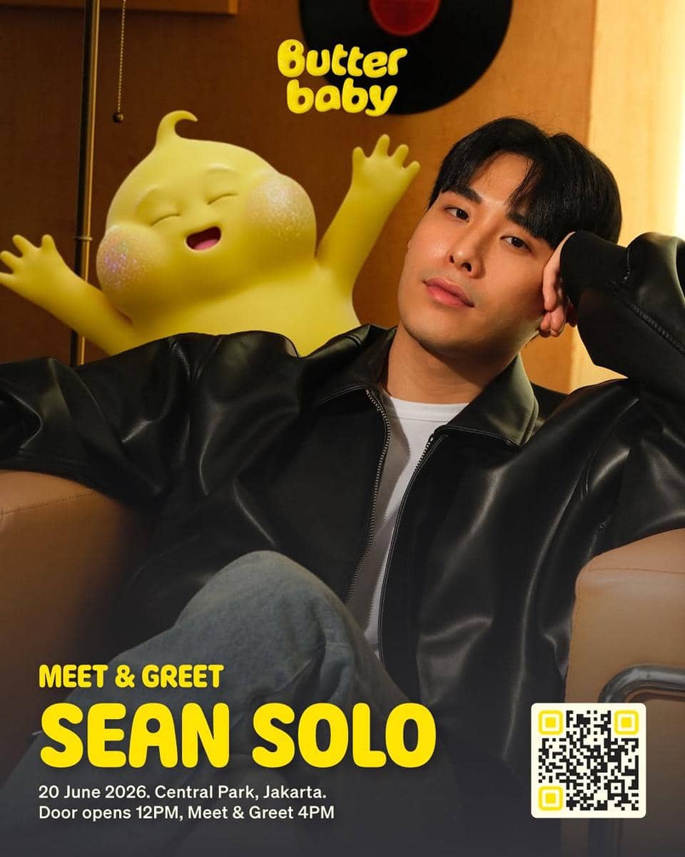 Seorang pria berjaket kulit hitam duduk santai di sofa dengan karakter animasi kuning tersenyum di belakangnya dan tulisan Butter Baby.