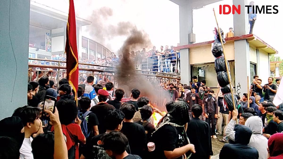 Kerumunan massa melakukan demonstrasi di depan Kantor DPRD Sulawesi Utara, dengan asap hitam mengepul di tengah aksi di Kota Manado.