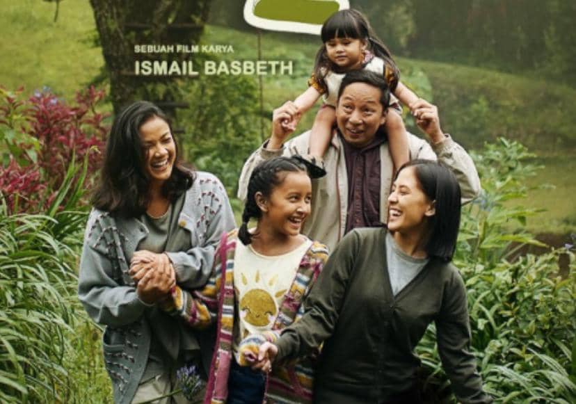 Poster film Keluarga Cemara 2 menampilkan lima anggota keluarga tersenyum bahagia di taman hijau dengan latar alam yang asri.