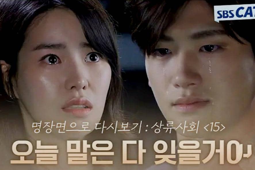 Dua karakter dalam drama High Society saling menatap dengan ekspresi emosional, satu di antaranya meneteskan air mata.