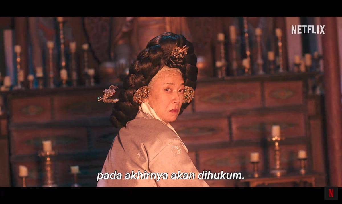 Seorang wanita berbusana tradisional Korea dengan tatanan rambut rumit menatap ke belakang dalam adegan drama The East Palace.