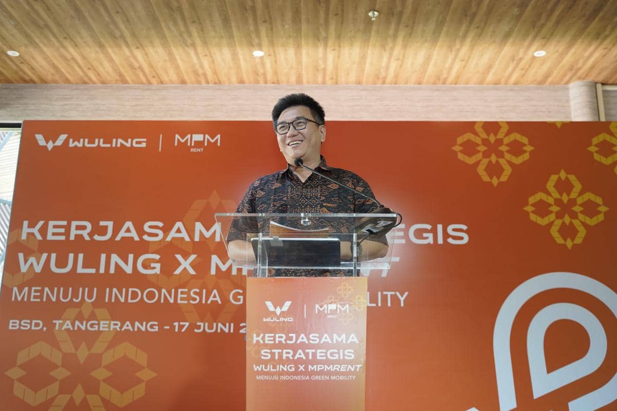 Seorang pria berbicara di podium dalam acara kerja sama strategis antara Wuling dan MPMRent di BSD, Tangerang.
