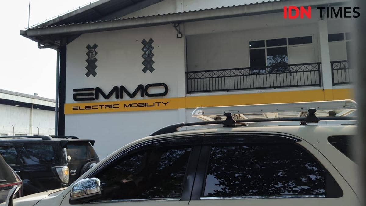 Tampak depan gudang motor listrik EMMO Electric Mobility di Kawasan Industri Sentul, Bogor, dengan beberapa mobil terparkir di depannya.