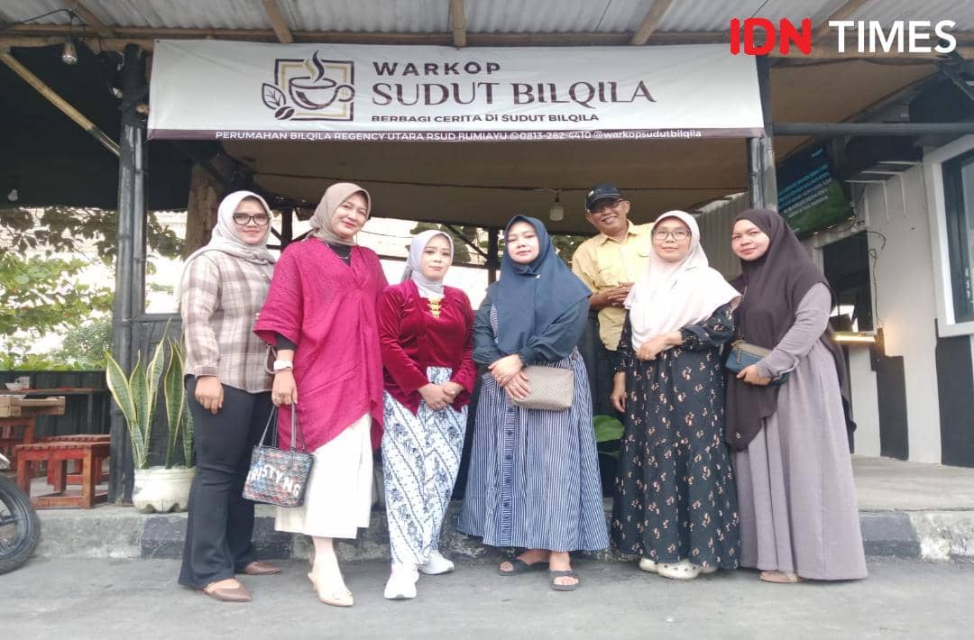 Sekelompok ibu rumah tangga berpose di depan Warkop Sudut Bilqila yang menjadi wadah produktif dan koperasi bagi anggotanya.