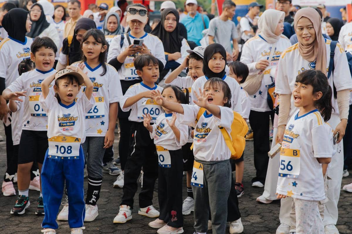 Anak-anak mengenakan kaus putih bertuliskan Little Star Fun Run 2026 bersemangat mengikuti kegiatan lari di Surabaya bersama orang tua.
