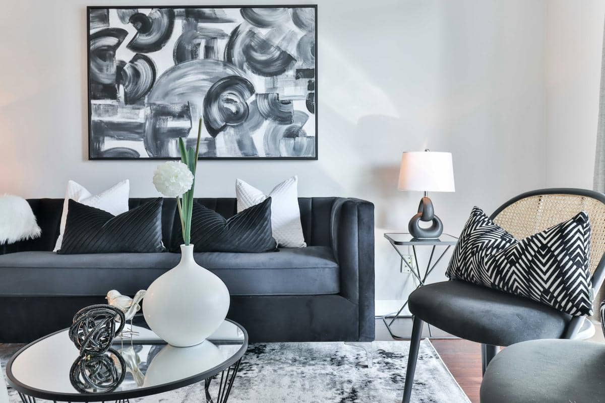 https://unsplash.com/id/foto/ruang-tamu-dengan-sofa-hitam-dan-meja-dengan-vas-dengan-bunga-di-atasnya-Nl1cP1Tr2oU