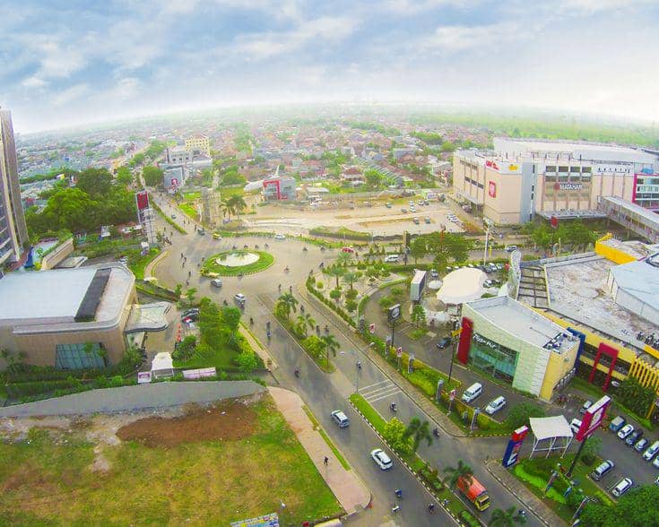 Pemandangan udara kawasan perkotaan Karawang dengan jalan raya, gedung perkantoran, pusat perbelanjaan, dan area hijau di sekitarnya.