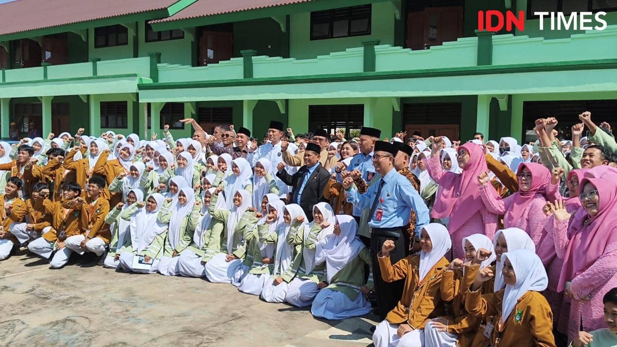 Menko berfoto bersama para siswa dan guru MTsN 1 Kota Bogor di halaman sekolah dengan latar gedung berwarna hijau.