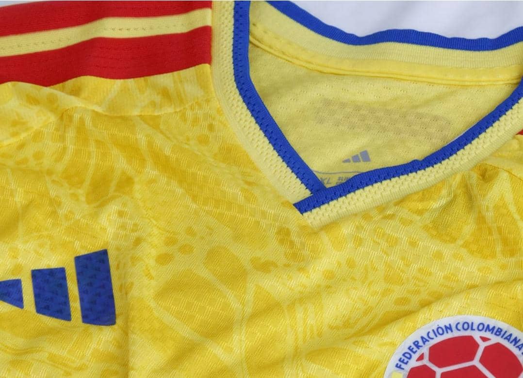 Jersey berwarna kuning dengan detail biru di bagian kerah dan logo Federacion Colombiana de Futbol di sisi kanan bawah.