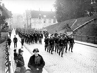 Tentara Belgia yang berbaris melewati Gerbang Menin di Ypres, Belgia, sesaat sebelum invasi Jerman pada Mei 1914.