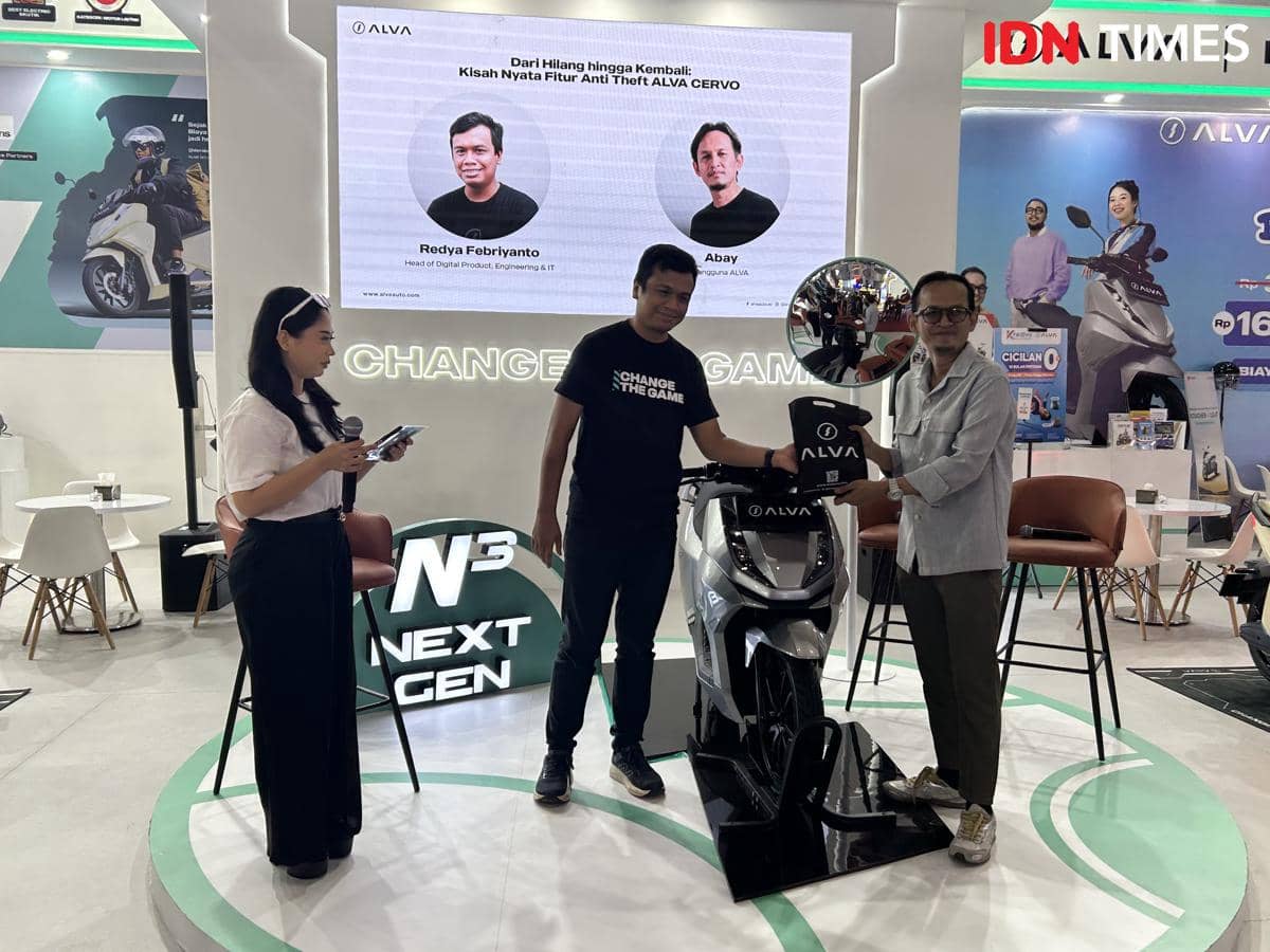 Seorang pengguna Alva Cervo menerima helm dari perwakilan Alva di sebuah acara peluncuran fitur anti pencurian motor listrik.