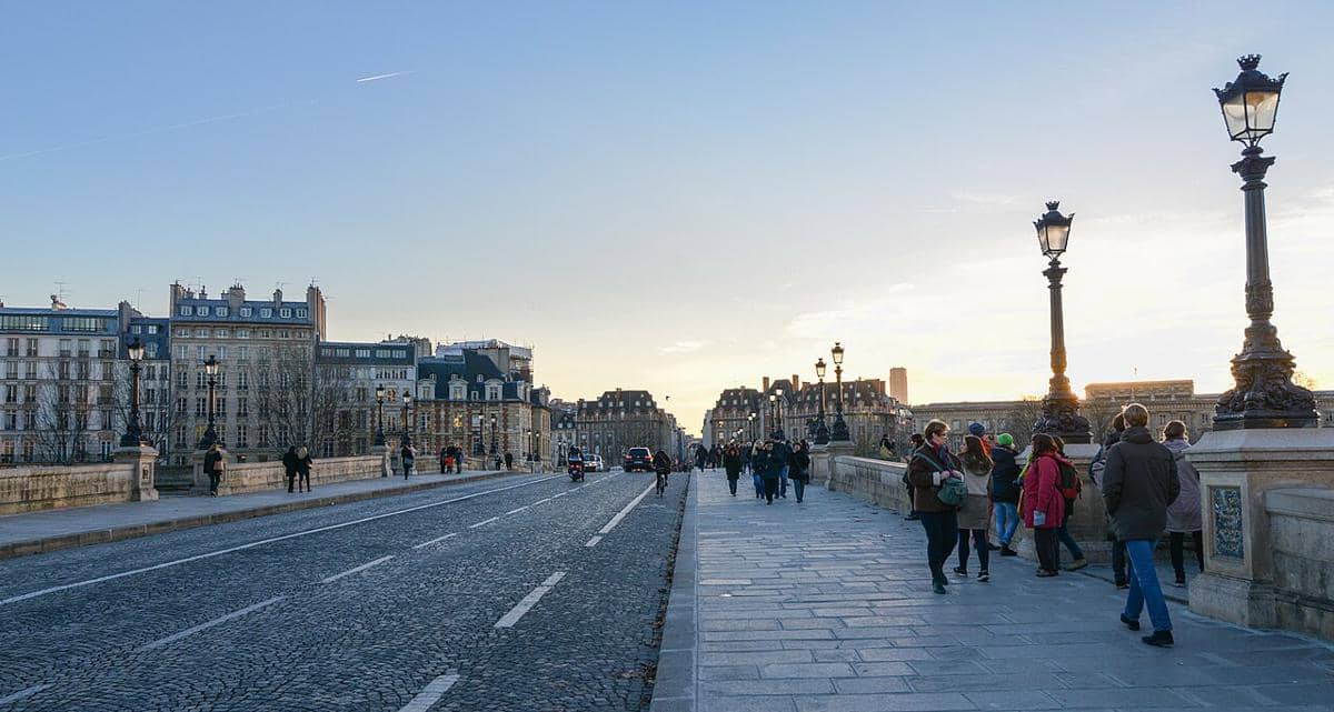 Orang-orang yang berada di trotoar pejalan kaki Pont Neuf.