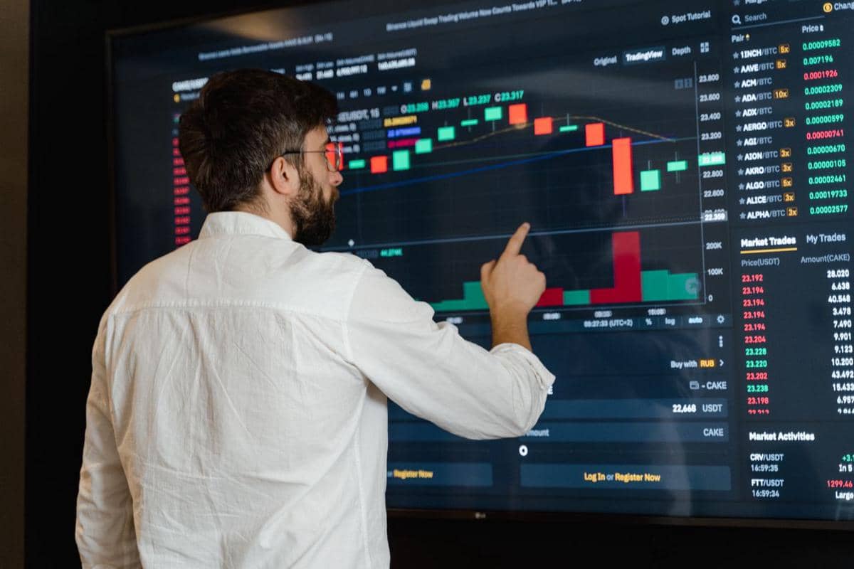 ilustrasi seorang pria menganalisis grafik mata uang kripto di monitor layar sentuh