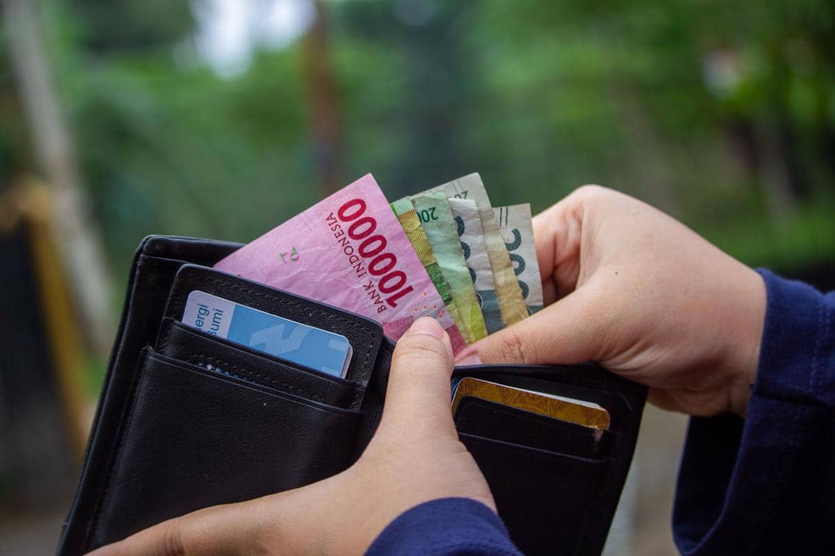Ilustrasi dompet dan uang Rupiah.