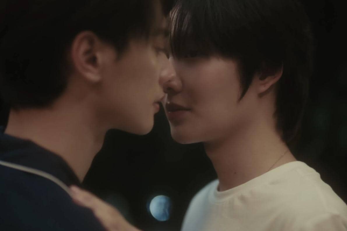 Dua pria saling berhadapan dengan jarak sangat dekat dalam adegan romantis dari drama Still Holding up like the Moon.