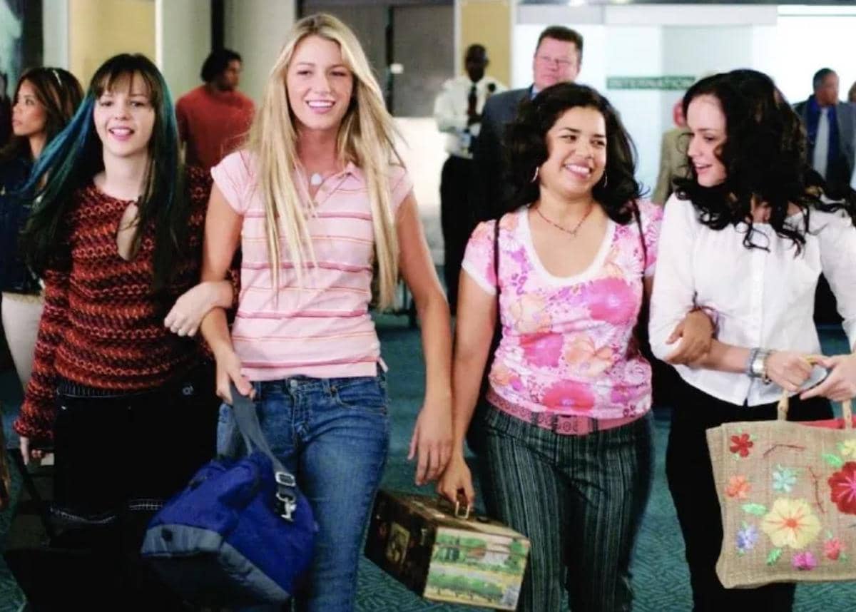 Empat remaja perempuan berjalan bersama di bandara sambil tersenyum dan membawa tas dalam cuplikan film The Sisterhood of the Traveling Pants.