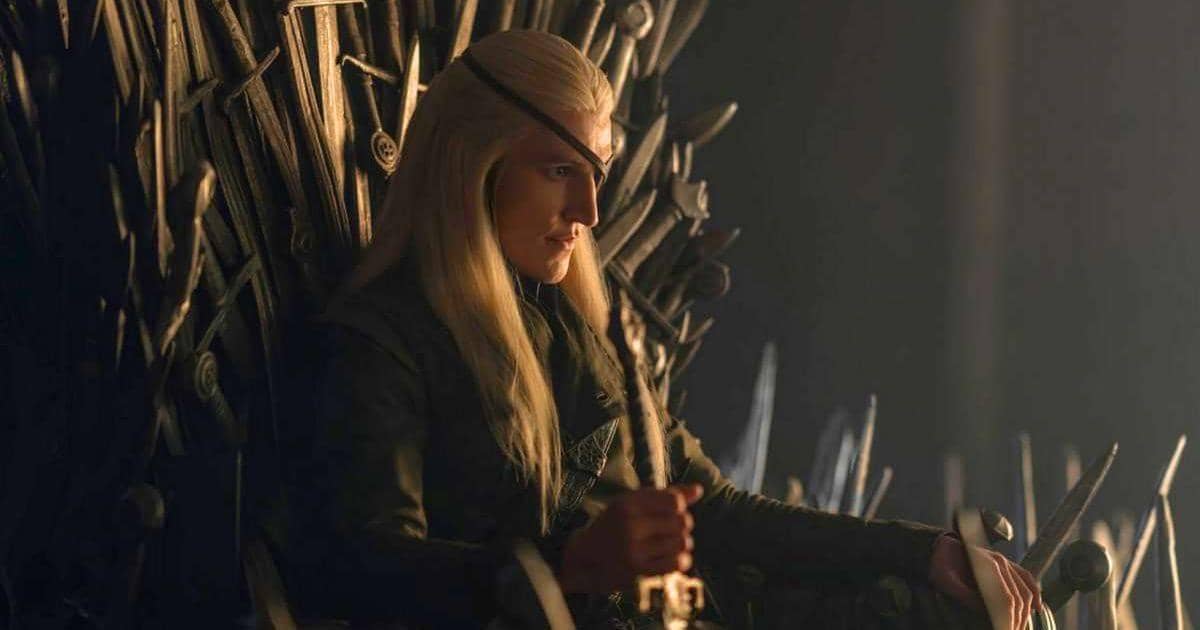 Seorang karakter berambut pirang panjang duduk di atas Iron Throne dengan ekspresi serius dalam adegan serial House of the Dragon.