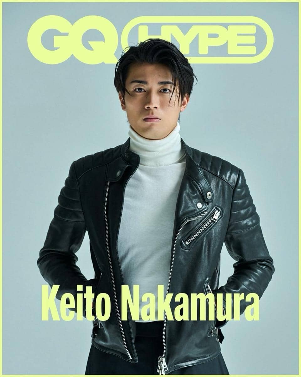 Keito Nakamura mengenakan jaket kulit hitam dan turtleneck putih berpose di depan latar abu-abu dengan logo GQ Hype di belakangnya.